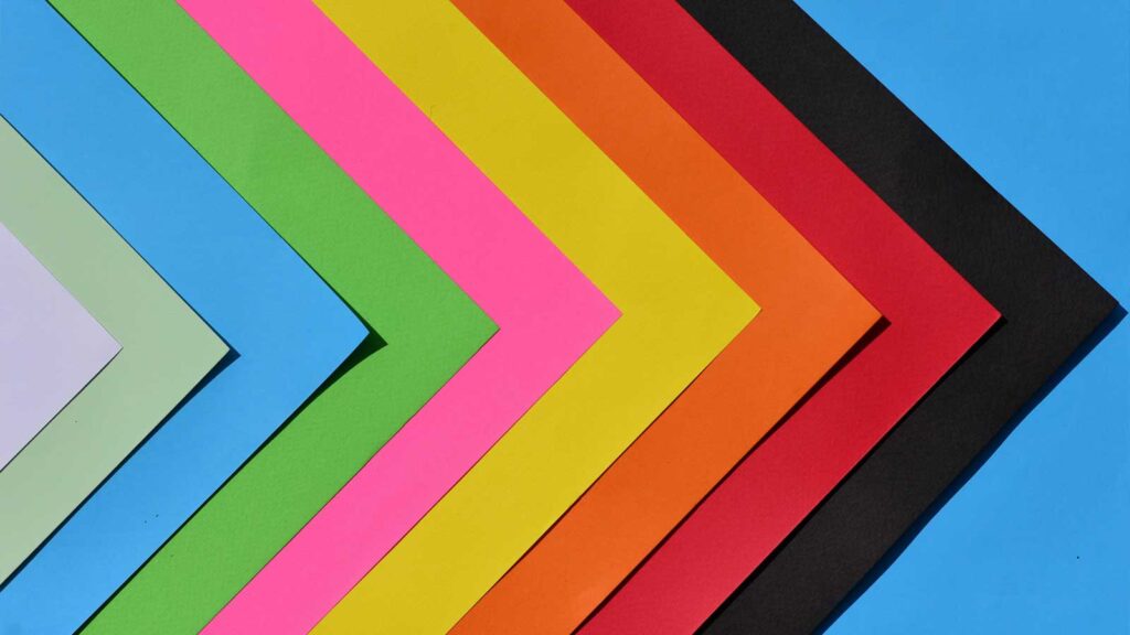 Multi-coloured paperwork, angled to make arrows